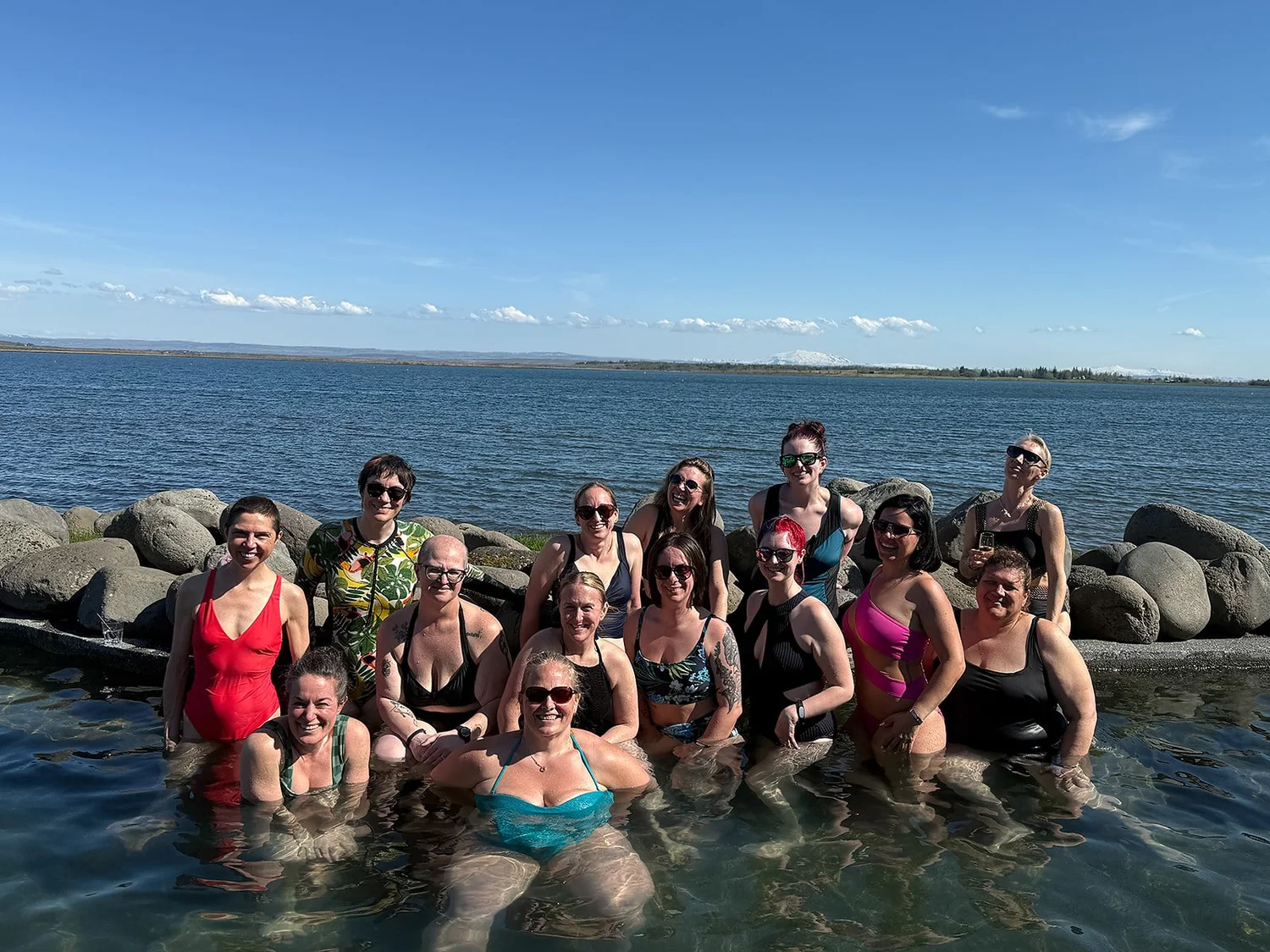 A smiling group of guests together in a geothermal pool