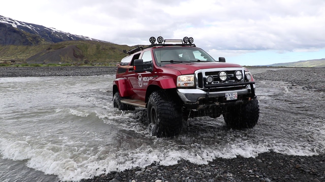 A super jeep fording a glacial river