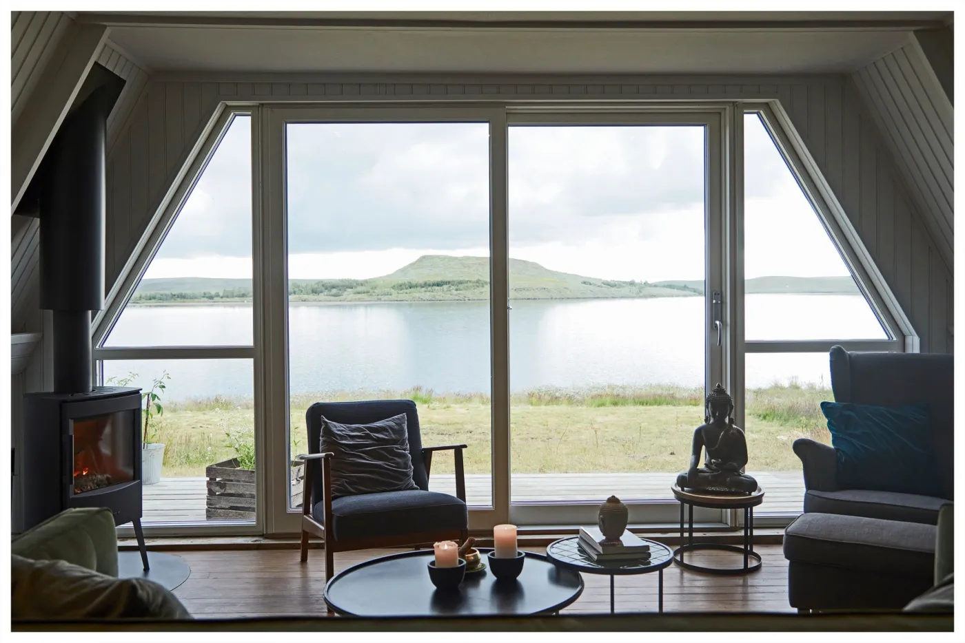 A fireside seating area with the lake through the windows